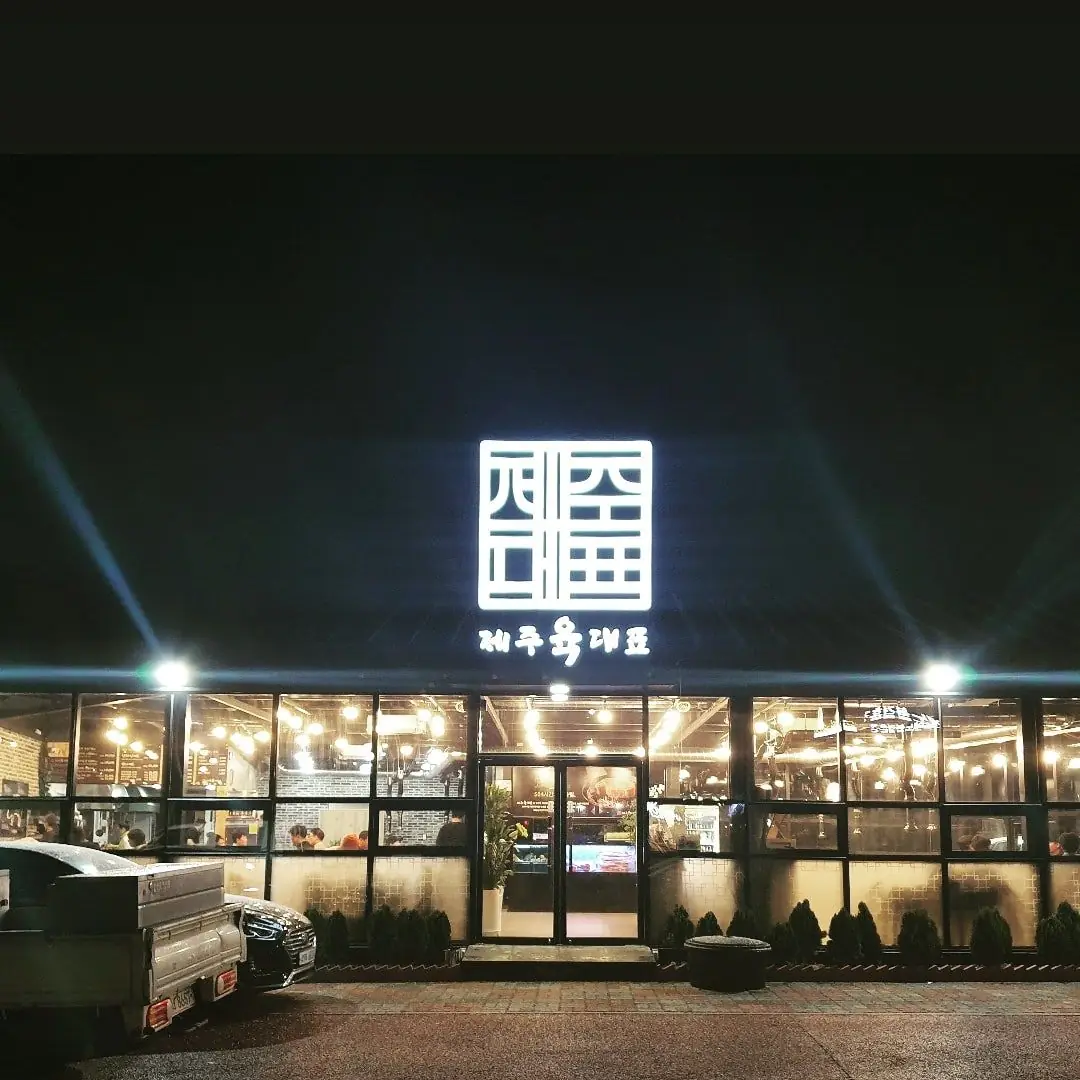 밤에 불 켜진 제주육대표 매장 외관